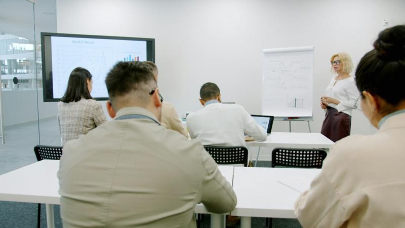 Instrutora apresentando para uma turma em sala de treinamento